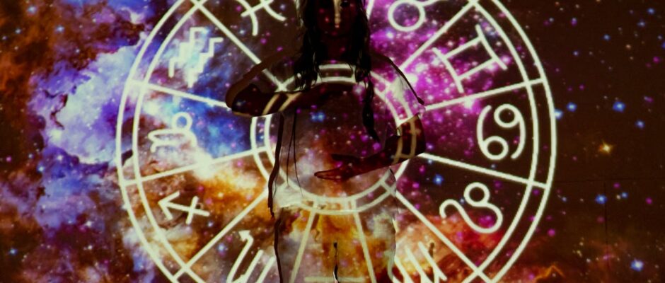 Woman standing with astrological symbols projected, evoking a mystical vibe.